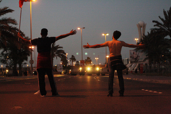Ali Sanqour stands bare-chested before military tanks preventing protestors from reaching Pearl Roundabout in 2011